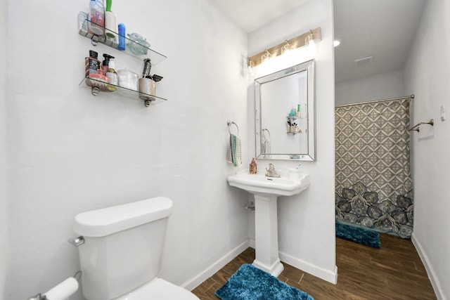 119 Burke Rd, Pasadena, TX 77506 - bathroom with wood finished floors, toilet, a shower with curtain, and baseboards