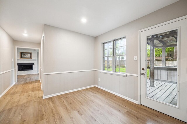 1802 Corral Dr, Houston, TX 77090 - doorway with wood finished floors, a fireplace, a wainscoted wall, and recessed lighting