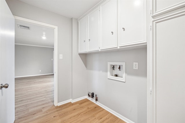 1802 Corral Dr, Houston, TX 77090 - laundry room featuring hookup for a washing machine, hookup for a gas dryer, light wood-style flooring, cabinet space, and baseboards