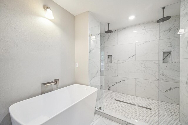 1802 Corral Dr, Houston, TX 77090 - full bath with a marble finish shower, a soaking tub, marble look tile flooring, and recessed lighting