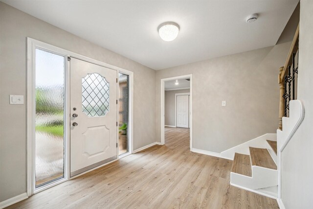 1802 Corral Dr, Houston, TX 77090 - foyer with light wood finished floors, baseboards, and stairway