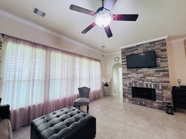21607 Goloby Dr, Richmond, TX 77407 - living area featuring a stone fireplace, crown molding, ceiling fan, and arched walkways