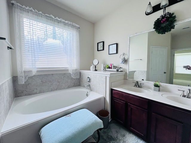 21607 Goloby Dr, Richmond, TX 77407 - bathroom featuring healthy amount of natural light, a garden tub, and double vanity