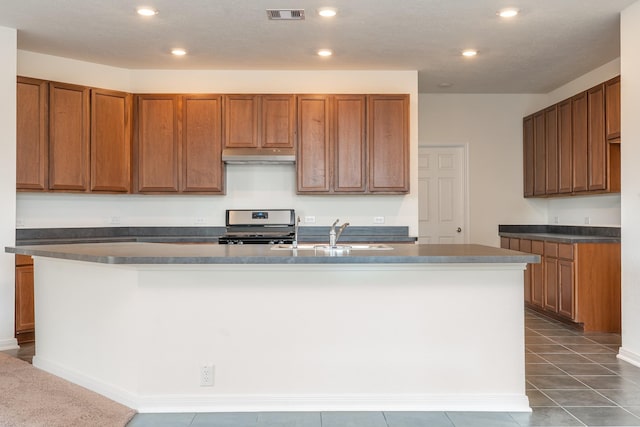 6120 Whitewing Rd, Rosenberg, TX 77469 - kitchen with stainless steel range, recessed lighting, under cabinet range hood, an island with sink, and brown cabinets