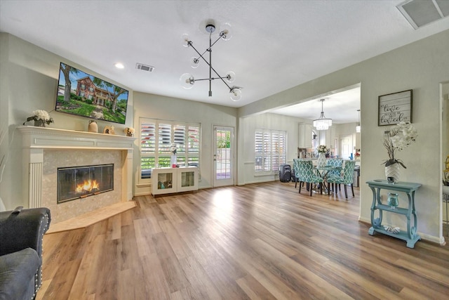 3602 Garrettsville Dr, Pearland, TX 77584 - living room featuring a chandelier, a premium fireplace, plenty of natural light, wood finished floors, and recessed lighting