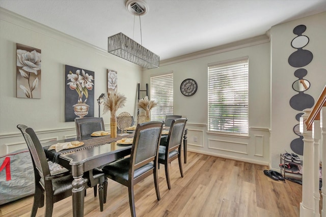 3602 Garrettsville Dr, Pearland, TX 77584 - dining area featuring a decorative wall, healthy amount of natural light, crown molding, wainscoting, and light wood finished floors