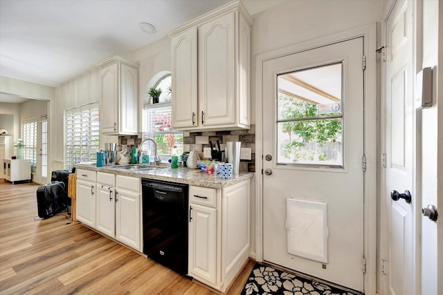 3602 Garrettsville Dr, Pearland, TX 77584 - kitchen with black dishwasher, light wood-style floors, a sink, and plenty of natural light