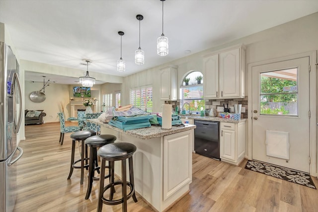 3602 Garrettsville Dr, Pearland, TX 77584 - kitchen with black dishwasher, stainless steel refrigerator with ice dispenser, white cabinets, and light wood-style flooring