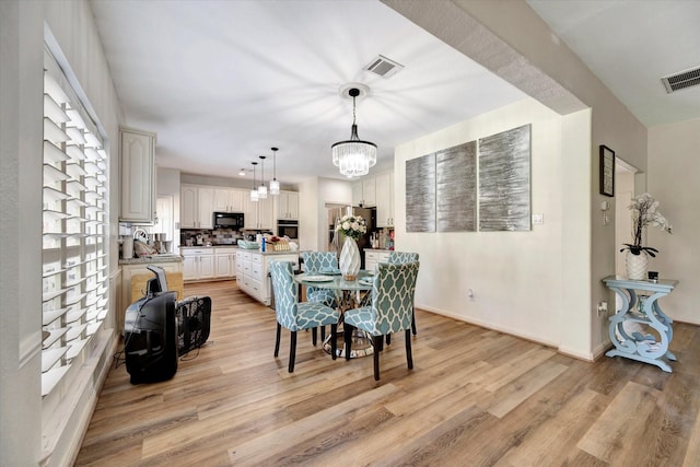 3602 Garrettsville Dr, Pearland, TX 77584 - dining space with light wood finished floors, a chandelier, and baseboards
