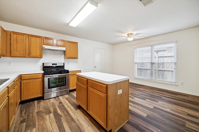 2818 Cocona Ln, Houston, TX 77073 - kitchen featuring stainless steel gas range oven, under cabinet range hood, dark wood-style floors, ceiling fan, and light countertops