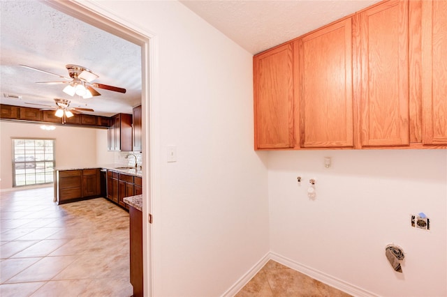 4430 Peridot Ln, Friendswood, TX 77546 - laundry room with a textured ceiling, a ceiling fan, light tile patterned floors, baseboards, and cabinet space