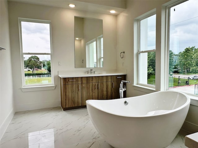 2806 Rosefield Dr, Houston, TX 77080 - bathroom with vanity, a freestanding bath, marble look tile flooring, baseboards, and recessed lighting