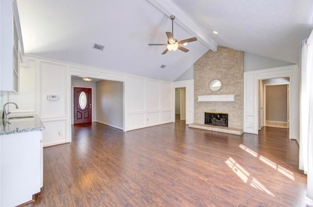 3838 Fawn Creek Dr, Houston, TX 77339 - unfurnished living room with a sink, a decorative wall, ceiling fan, a brick fireplace, and dark wood finished floors