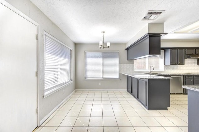 3838 Fawn Creek Dr, Houston, TX 77339 - kitchen featuring stainless steel dishwasher, tasteful backsplash, a chandelier, a textured ceiling, and under cabinet range hood