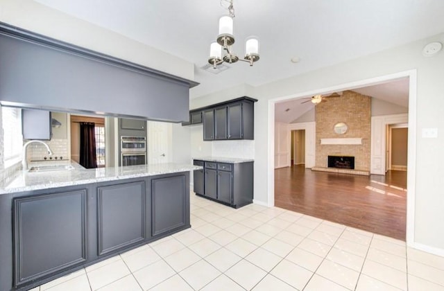 3838 Fawn Creek Dr, Houston, TX 77339 - kitchen with a sink, a chandelier, vaulted ceiling, double oven, and a ceiling fan