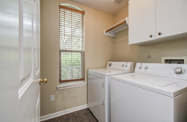 2107 Blue Water Bay Dr, Katy, TX 77494 - laundry room with baseboards, washing machine and clothes dryer, cabinet space, and dark marble finish flooring