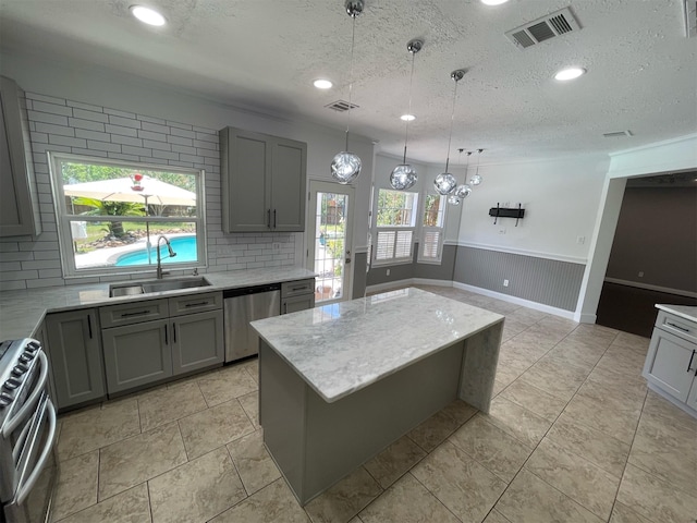 7802 Strathclyde Sound Rd, Houston, TX 77095 - kitchen with stainless steel appliances, a sink, gray cabinets, a textured ceiling, and a wainscoted wall