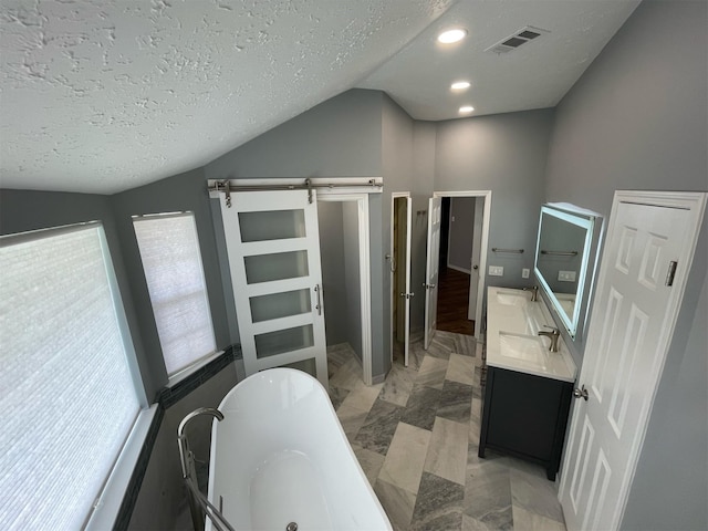 7802 Strathclyde Sound Rd, Houston, TX 77095 - full bathroom with marble finish floors, a freestanding tub, lofted ceiling, vanity, and a textured ceiling