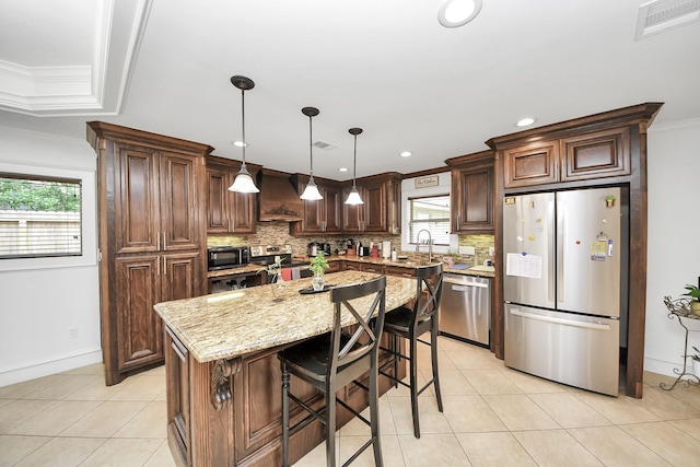 24 Woody Creek Dr, Conroe, TX 77301 - kitchen with stainless steel appliances, custom exhaust hood, backsplash, healthy amount of natural light, and recessed lighting