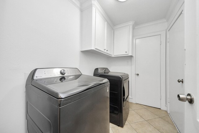 24 Woody Creek Dr, Conroe, TX 77301 - washroom with washing machine and clothes dryer, cabinet space, light tile patterned flooring, and crown molding