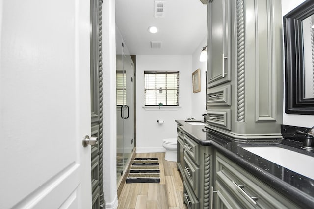 24 Woody Creek Dr, Conroe, TX 77301 - bathroom featuring toilet, double vanity, a shower stall, baseboards, and wood finished floors