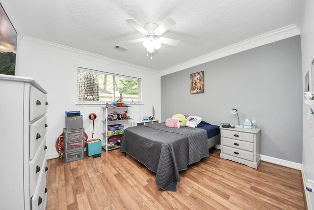 24 Woody Creek Dr, Conroe, TX 77301 - bedroom featuring crown molding, light wood-type flooring, a textured ceiling, ceiling fan, and baseboards