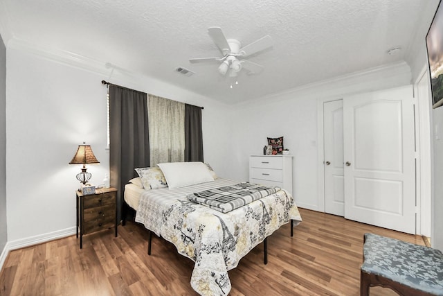 24 Woody Creek Dr, Conroe, TX 77301 - bedroom featuring wood finished floors, ornamental molding, a textured ceiling, baseboards, and ceiling fan