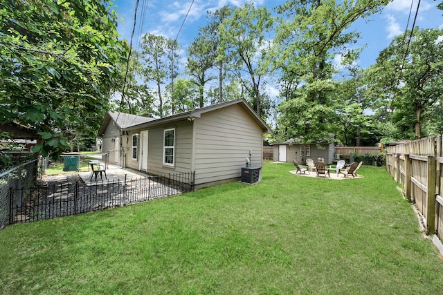24 Woody Creek Dr, Conroe, TX 77301 - back of property featuring an outdoor fire pit, a patio area, central AC, and an outbuilding