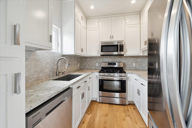 4209 Billingsley St, Houston, TX 77009 - kitchen with appliances with stainless steel finishes, a sink, white cabinets, light wood-style flooring, and recessed lighting