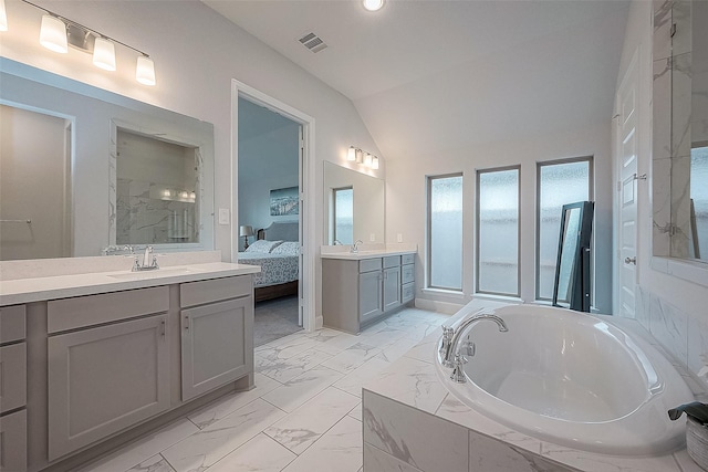 29042 Hauter Way, Fulshear, TX 77441 - full bath with marble look tiles, a bath, two vanities, ensuite bath, and vaulted ceiling