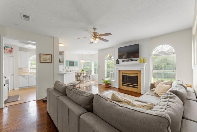 44 Parkway Pl, Houston, TX 77040 - living area featuring ceiling fan, wood finished floors, a glass covered fireplace, and a textured ceiling