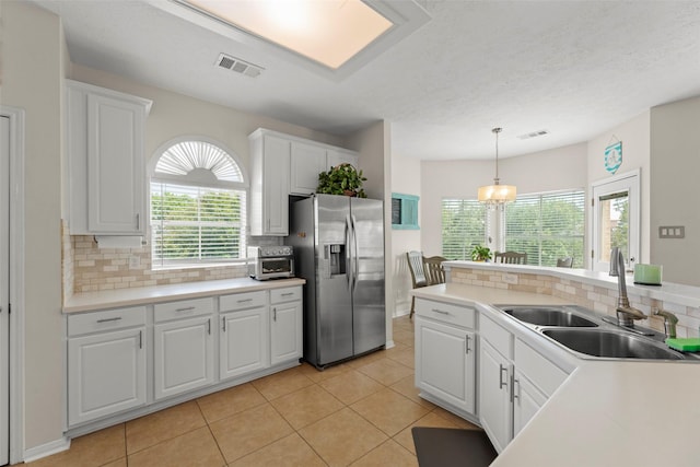 44 Parkway Pl, Houston, TX 77040 - kitchen with stainless steel fridge with ice dispenser, a sink, backsplash, white cabinets, and light tile patterned flooring