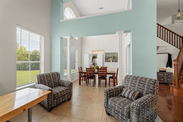 44 Parkway Pl, Houston, TX 77040 - living room featuring a towering ceiling, decorative columns, light tile patterned floors, a chandelier, and stairway