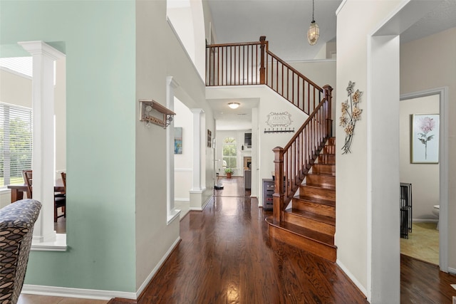 44 Parkway Pl, Houston, TX 77040 - entrance foyer featuring ornate columns, wood finished floors, stairway, a high ceiling, and baseboards