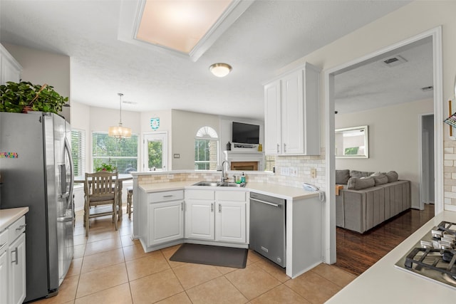 44 Parkway Pl, Houston, TX 77040 - kitchen featuring stainless steel appliances, a sink, white cabinetry, tasteful backsplash, and light countertops