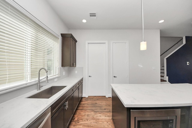 310 Eado Park Cir, Houston, TX 77020 - kitchen with a sink, wood finished floors, dark brown cabinets, recessed lighting, and hanging light fixtures
