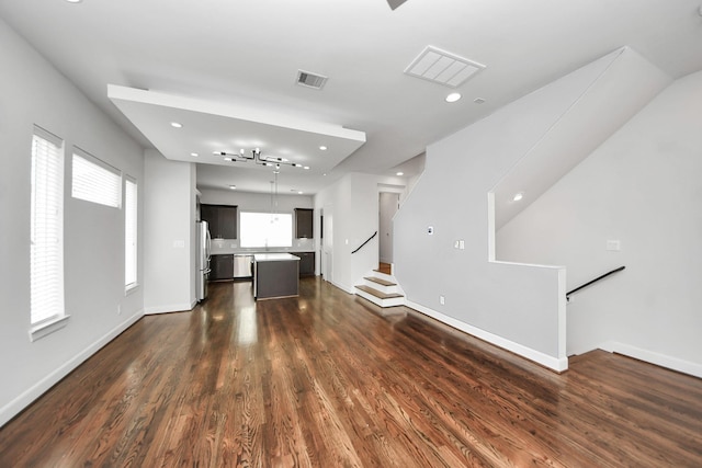 310 Eado Park Cir, Houston, TX 77020 - unfurnished living room featuring dark wood finished floors, healthy amount of natural light, baseboards, recessed lighting, and stairway
