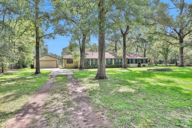 5614 Whipporwill Rd, Conroe, TX 77303 - ranch-style house featuring a garage, an outbuilding, and a front yard