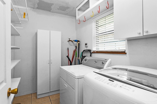 5614 Whipporwill Rd, Conroe, TX 77303 - laundry area featuring cabinet space, washer and dryer, and light tile patterned floors