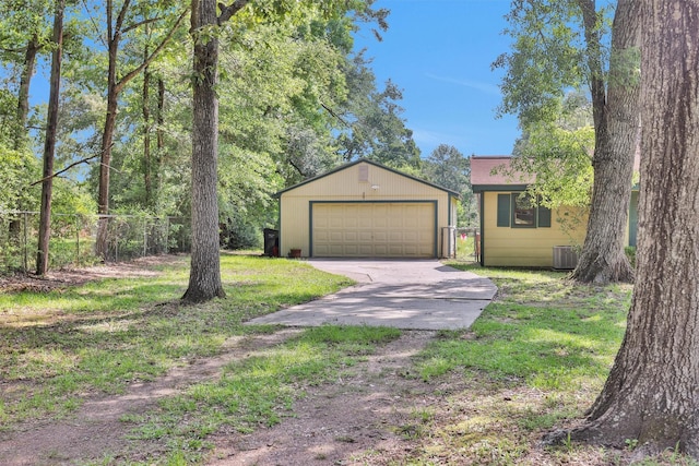 5614 Whipporwill Rd, Conroe, TX 77303 - view of front facade featuring an outdoor structure, central AC, a detached garage, and driveway