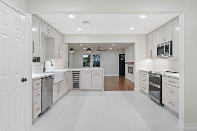 3734 Florinda St, Houston, TX 77021 - kitchen with stainless steel appliances, wine cooler, a peninsula, backsplash, and light countertops