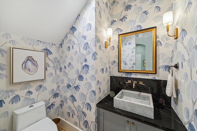 1917 Ebony Ln, Houston, TX 77018 - bathroom featuring wallpapered walls, vanity, and vaulted ceiling
