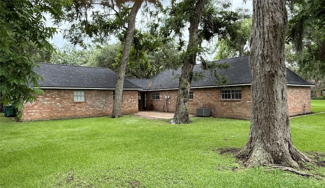 200 Wentworth Dr, West Columbia, TX 77486 - back of property with roof with shingles, cooling unit, brick siding, and a yard