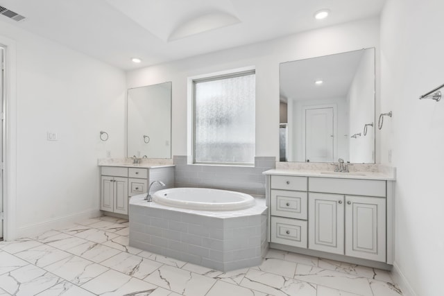 15003 Big Spring Park Dr, Cypress, TX 77433 - bathroom featuring marble look tile flooring, a garden tub, two vanities, and recessed lighting