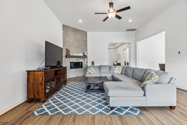 15003 Big Spring Park Dr, Cypress, TX 77433 - living room with ceiling fan, wood finished floors, a tiled fireplace, and recessed lighting