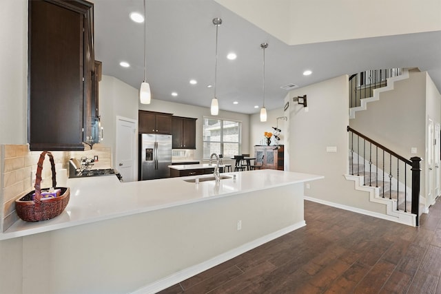 17040 Shy Leaf Ct, Conroe, TX 77385 - kitchen with stainless steel refrigerator with ice dispenser, a sink, dark brown cabinets, dark wood-type flooring, and recessed lighting