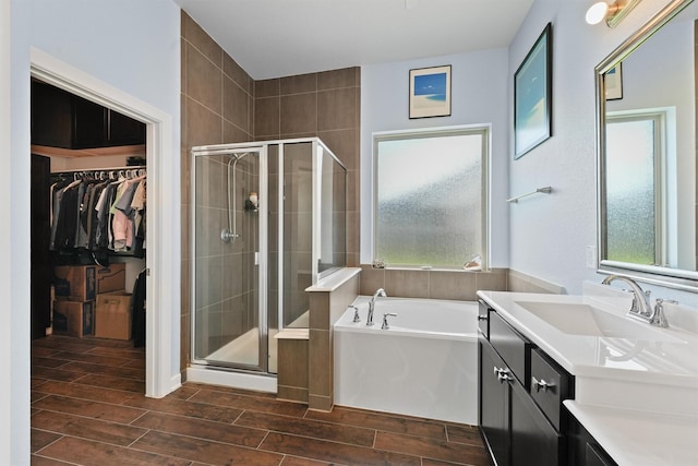 17040 Shy Leaf Ct, Conroe, TX 77385 - bathroom with vanity, wood finish floors, a shower stall, a bath, and a spacious closet