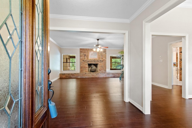 22402 Timber Ridge Dr, Magnolia, TX 77355 - unfurnished living room featuring a ceiling fan, crown molding, dark wood-style flooring, a fireplace, and baseboards