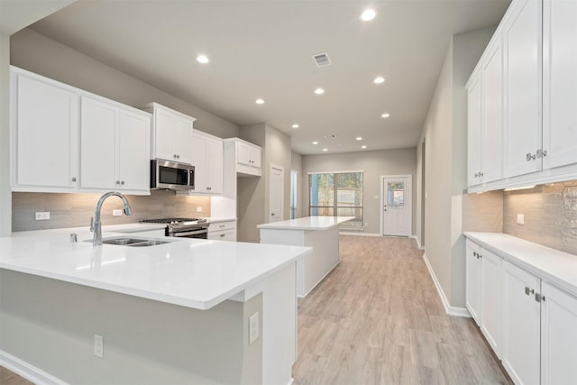 119 Lukewood Cir, Conroe, TX 77318 - kitchen with stainless steel appliances, a sink, tasteful backsplash, a kitchen island, and recessed lighting