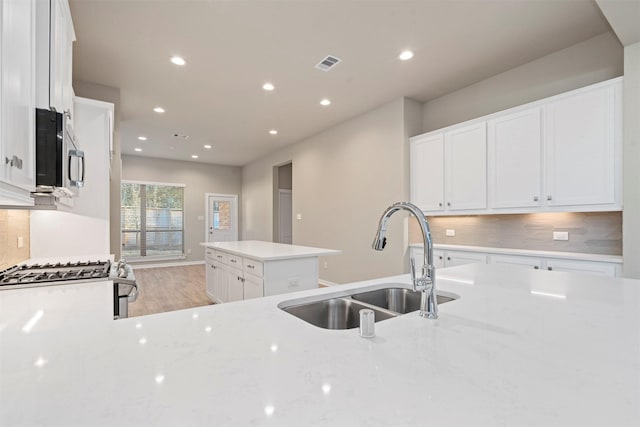 119 Lukewood Cir, Conroe, TX 77318 - kitchen featuring stainless steel appliances, a sink, tasteful backsplash, recessed lighting, and white cabinets